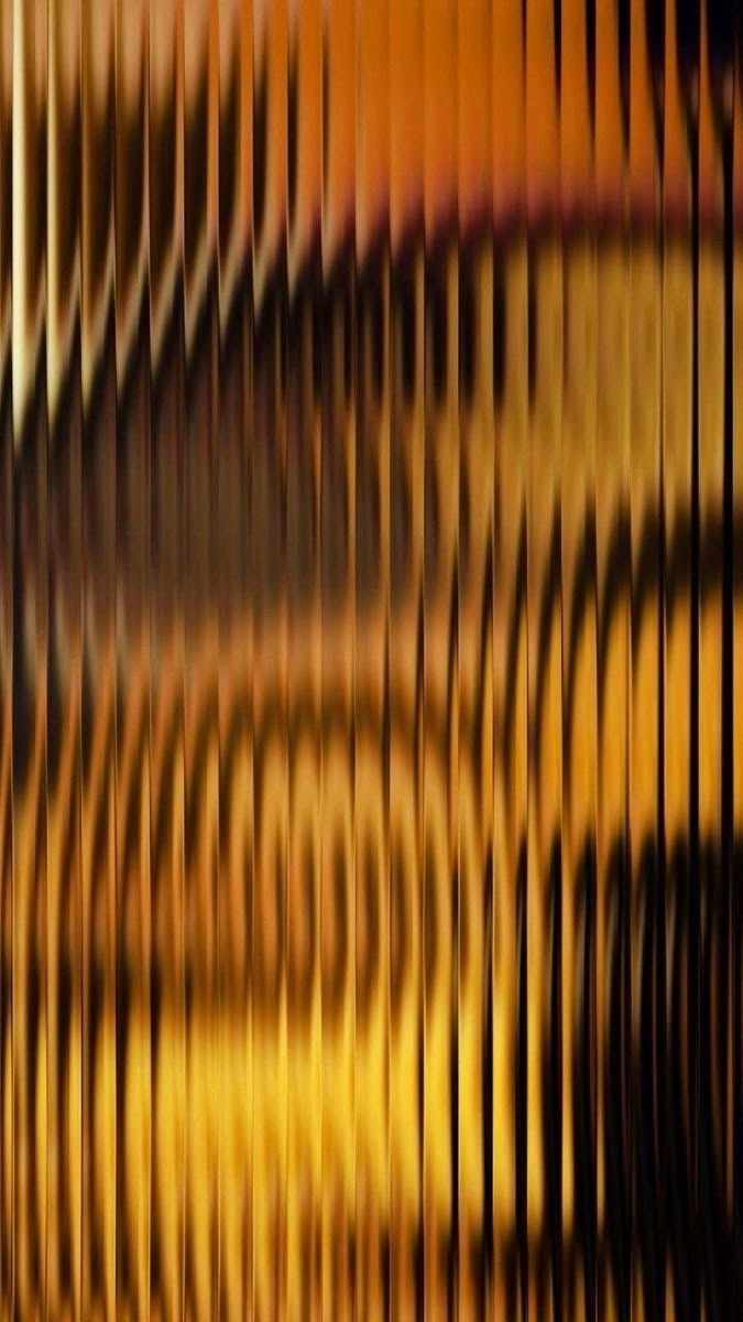 Abstract amber ribbed glass texture.