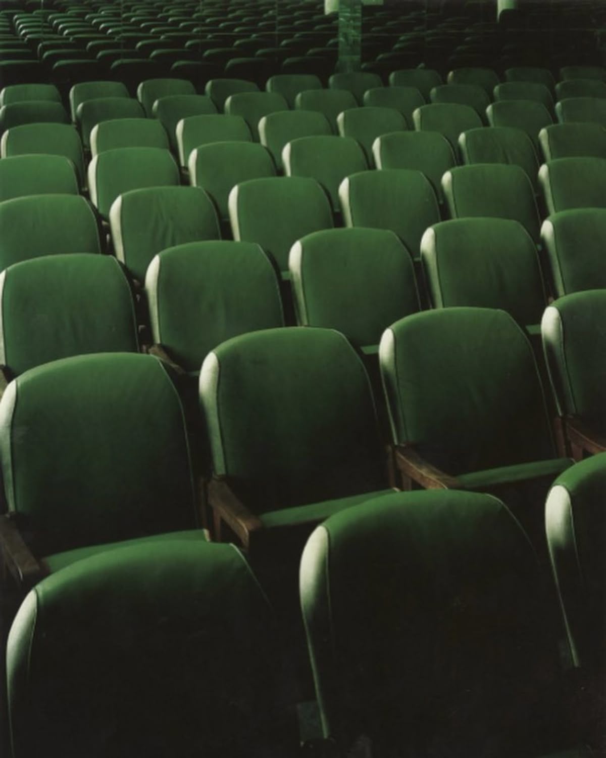 Rows of auditorium seats in warm light.