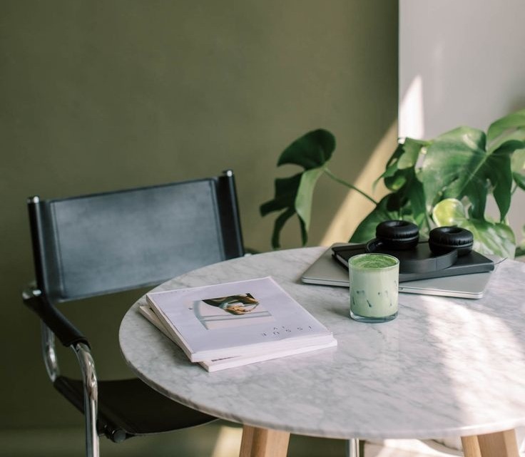 Marble table, leather chair and studio details in natural light.
